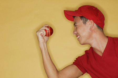 Young man holding a ball, side view