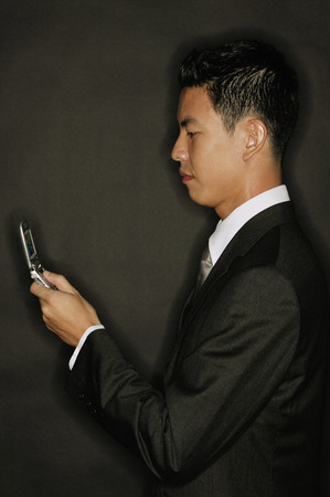 Young man using mobile phone, text messagingの写真素材