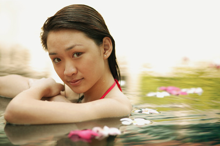Young woman in swimming pool, looking at cameraの写真素材
