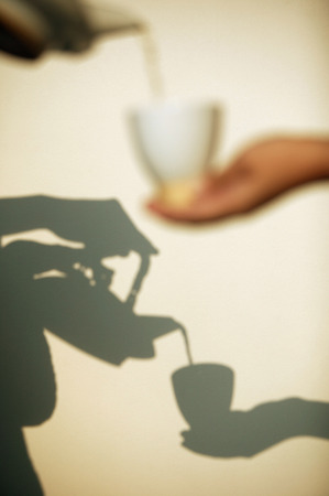 Pouring tea, shadow in the backgroundの写真素材