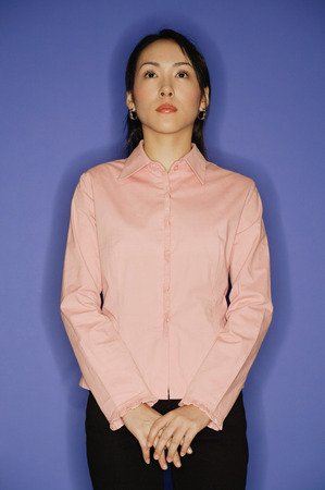 Young woman, standing, hands claspedの写真素材