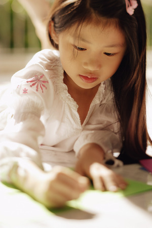 Young girl looking down, writingの写真素材