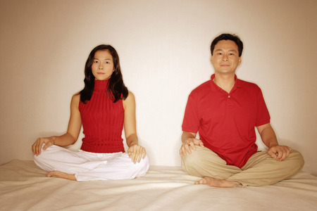 Man and woman sitting side by side, legs crossedの写真素材