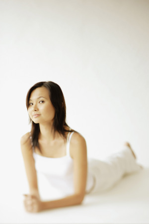 Young woman lying on floor, looking at cameraの写真素材