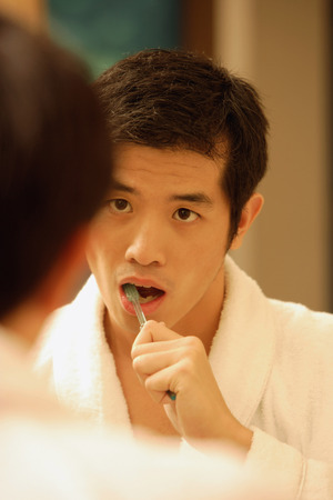 Young man brushing his teethの写真素材