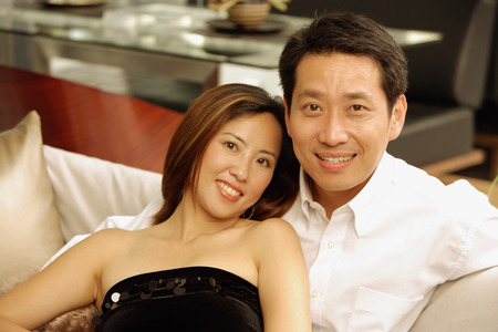 Couple on sofa, looking at cameraの写真素材