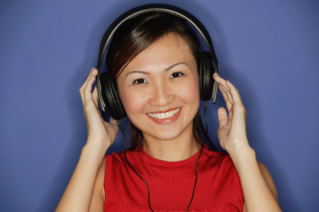 Young woman wearing headphones,  smilingの写真素材