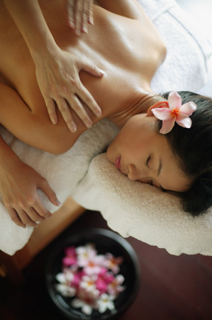 Young woman receiving back massageの写真素材