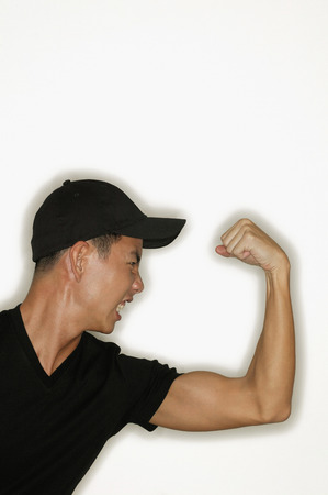 Young man flexing muscles, mouth openの写真素材