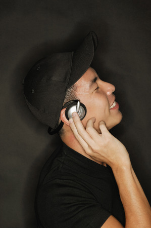 Young man with headphones, black backgroundの写真素材