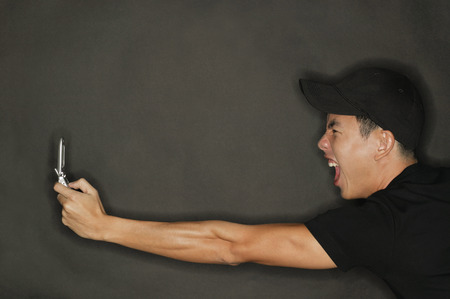 Young man holding mobile phone, profileの写真素材