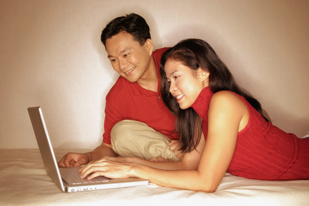 Man and woman side by side, using laptopの写真素材