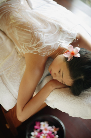 Young woman lying on massage table, eyes closedの写真素材