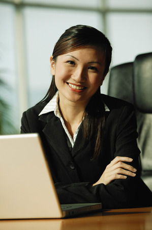 Young woman looking at camera, arms crossedの写真素材