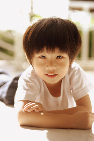 Young boy looking at camera, arms crossedの写真素材