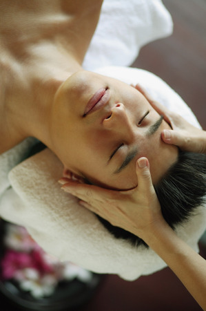 Young man receiving head massageの写真素材