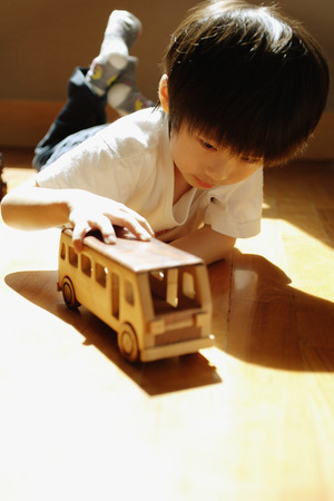 Young boy playing with toy busの写真素材
