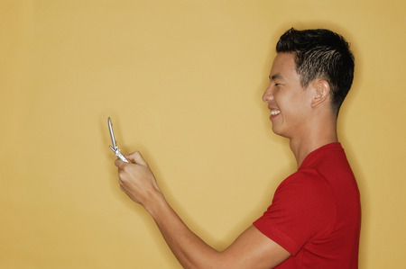 Young man holding mobile phone, profileの写真素材