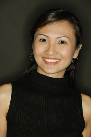 Young woman wearing a black top, smilingの写真素材