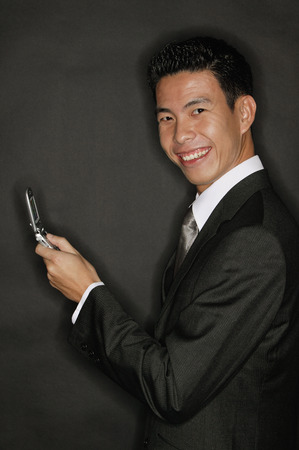 Young man holding mobile phoneの写真素材