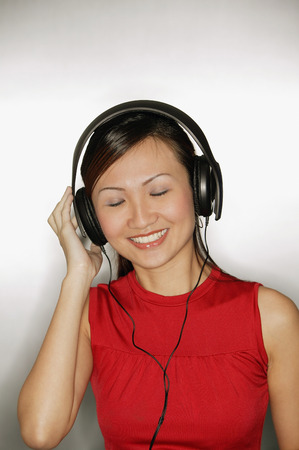 Young woman wearing headphones,  smilingの写真素材