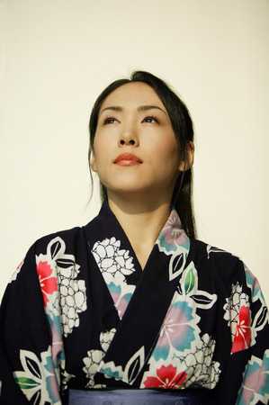 Young woman wearing a kimono, looking up.の写真素材