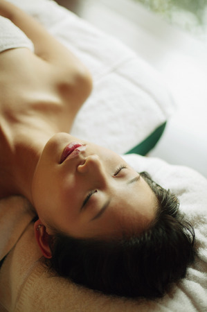 Young woman lying down on massage tableの写真素材