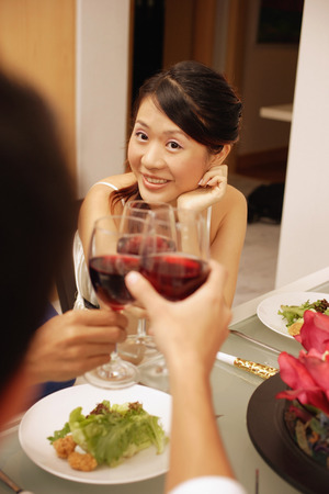 Friends at dinner table, toasting with wine glassesの写真素材