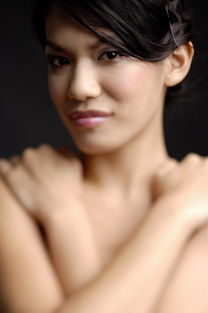 Portrait of a young woman, arms crossed over chest, looking at cameraの写真素材