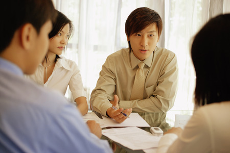 Young executives sitting face to face, having a meetingの写真素材