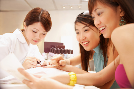 Young women having their nails painted at nail salonの写真素材