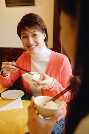 Young women eating at a Chinese restaurantの写真素材