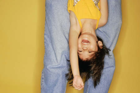 Father carrying daughter upside down.の写真素材