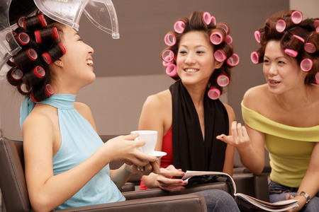 Young women at beauty salon, drinking tea and talkingの写真素材