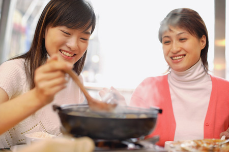 Young women having soup at restaurantの写真素材