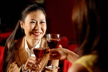 Two women toasting with wine glasses.の写真素材