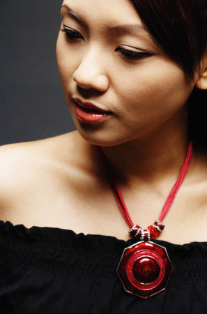 Young woman wearing necklace, looking awayの写真素材