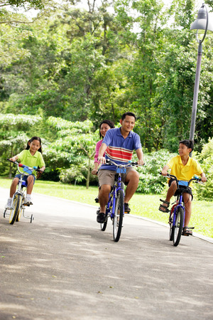 Family with two children, cycling side by side