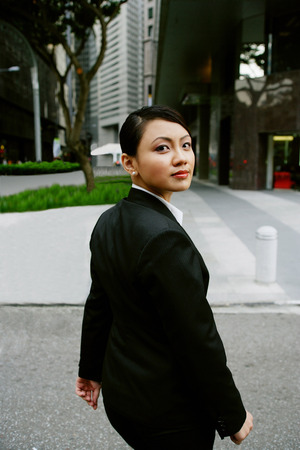 Business women walking, turning to looking at cameraの写真素材