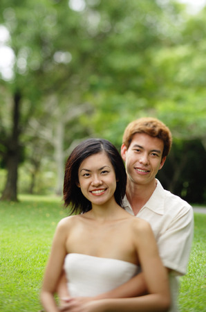 Couple embracing, looking at cameraの写真素材