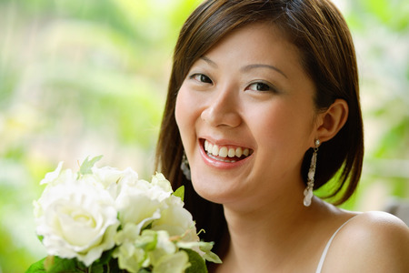 Young woman holding a bouquet of flowers, smilingの写真素材