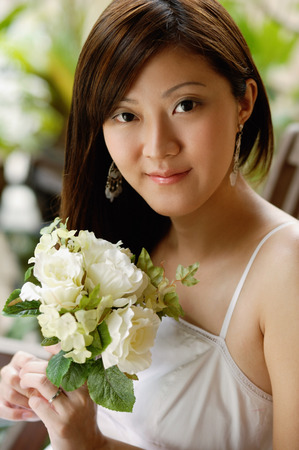 Young woman holding a bouquet of flowers, portraitの写真素材