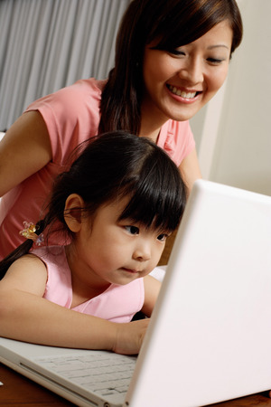 Mother and daughter using laptopの写真素材