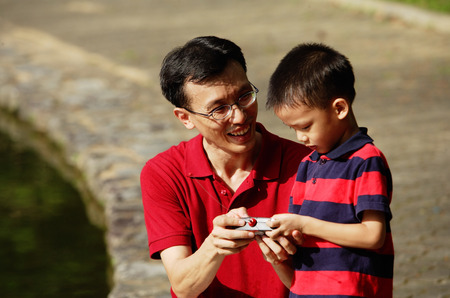 Father and son looking at remote control