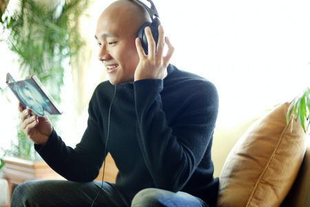Man in black turtleneck, with headphones, listening to musicの写真素材