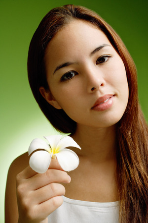 Young woman holding Frangipani flowerの写真素材