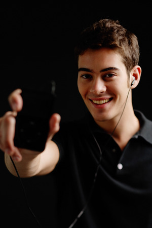 Man holding MP3 player towards cameraの写真素材
