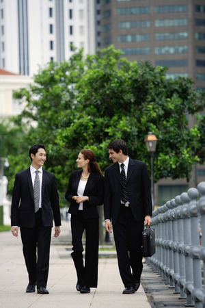 Business people walking side by side, talkingの写真素材