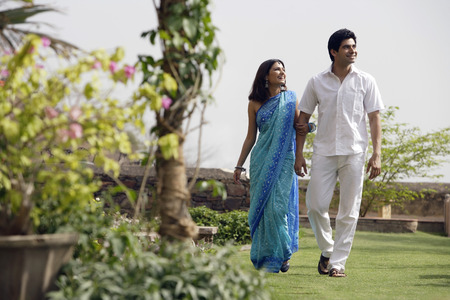 young couple strolling in gardenの写真素材