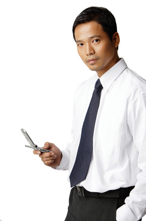 Young executive, holding mobile phone, looking at cameraの写真素材